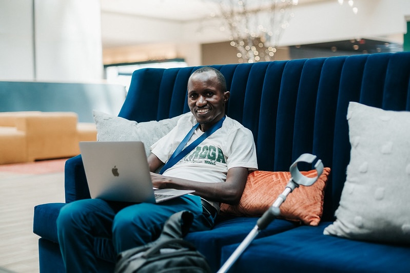 Attendee smiling while working on a laptop in the hotel lobby