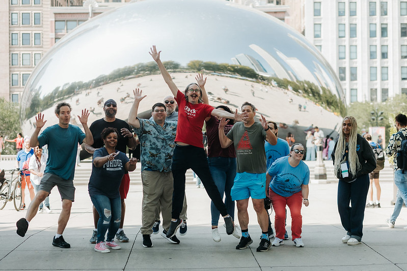 Group of attendees jumping in front of Cloud Gate (The Bean) in Chicago
