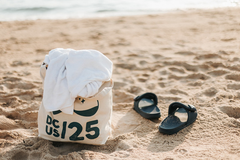 DjangoCon US 2025 tote bag on Chicago beach with sandals